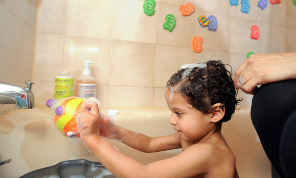 Stock image of Baby Playing with Doll in Shower