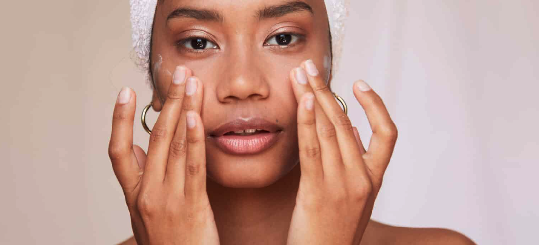 Stock Image of Model Applying Cream Under Eyes